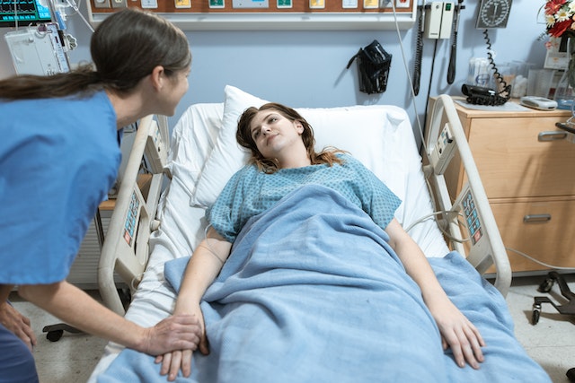 Nurse interacting with a patient in a hospital bed, showcasing care and support in a medical environment.